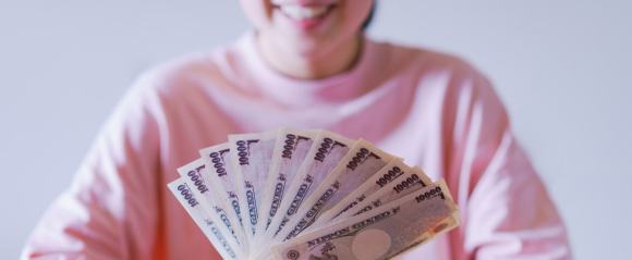 お金を見て喜ぶ女性のイメージ