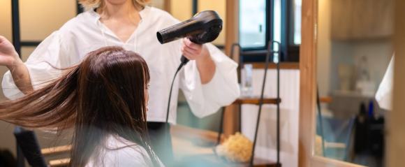美容院で髪を乾かしてもらう女性のイメージ