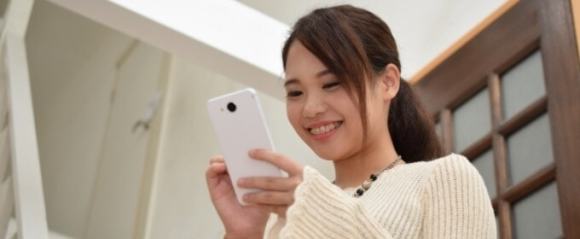 スマホでSNSの更新をしている女性